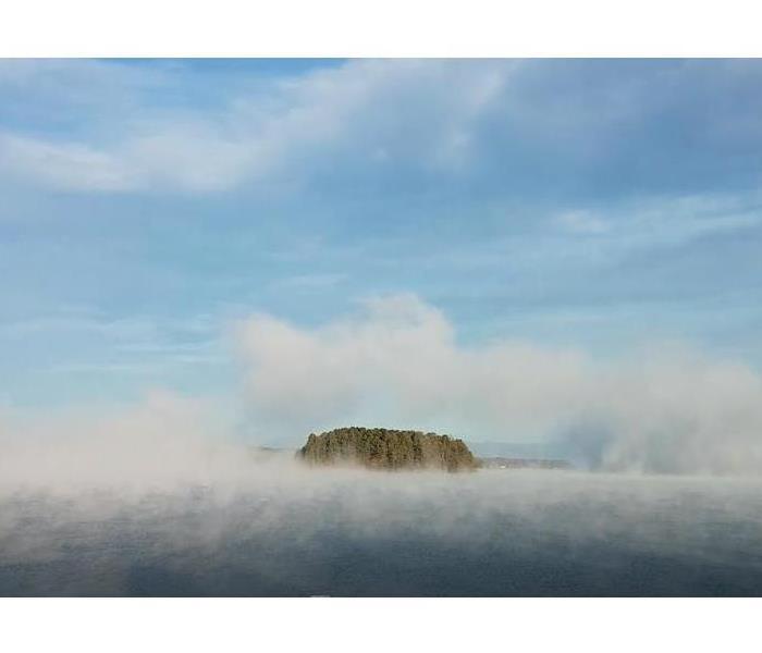Fog covering water and exposes an island in the center